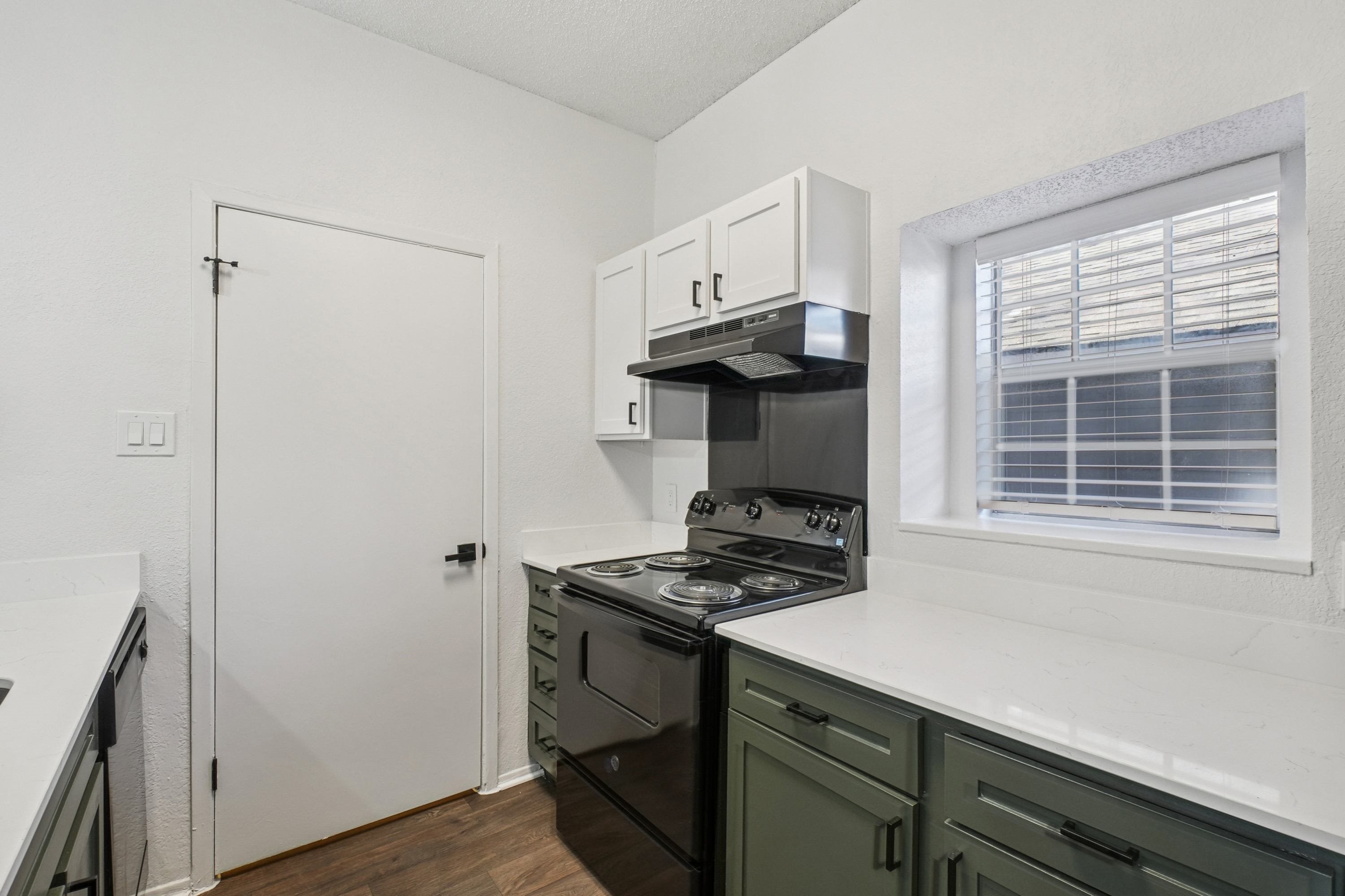 A kitchen with a stove, oven, and cabinets.